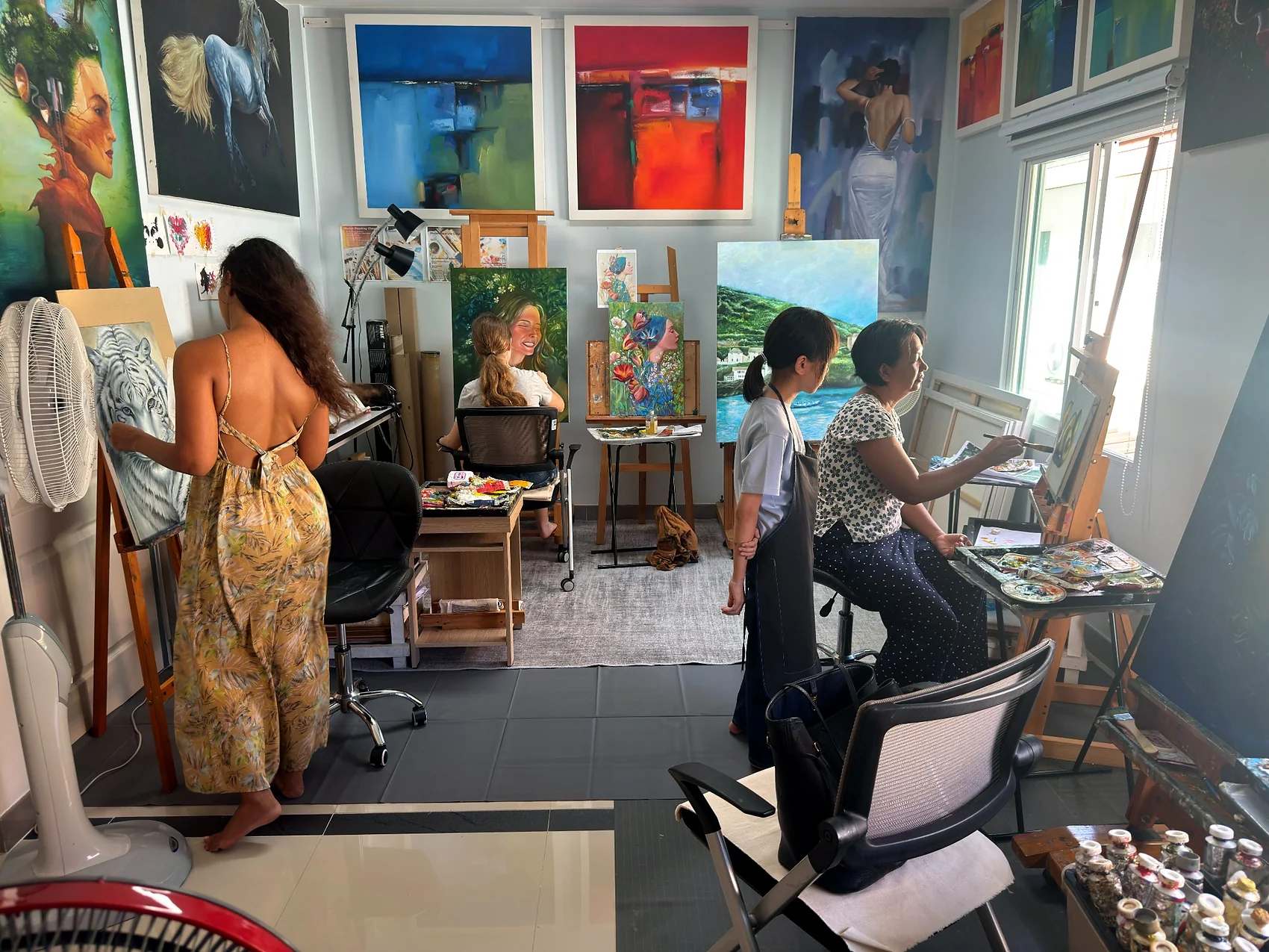 A mixed group working on paintings inside the studio